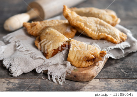 Homemade sweet pumpkin empanadillas on wooden table Homemade sweet pumpkin empanadillas on wooden table 135880545