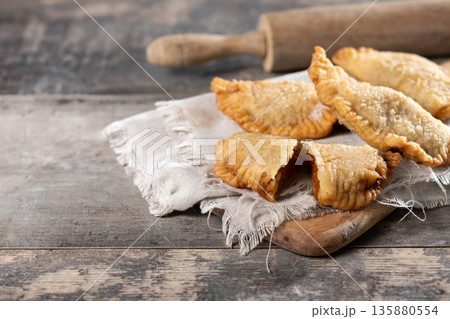 Homemade sweet pumpkin empanadillas on wooden table Homemade sweet pumpkin empanadillas on wooden table 135880554