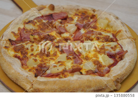 closeup bacon, cheese, pineapple pizza in a wooden tray on the table background, food, hot, snack, eat, copy space closeup bacon, cheese, pineapple pizza in a wooden tray on the table background, food, hot, snack, eat, copy space 135880558