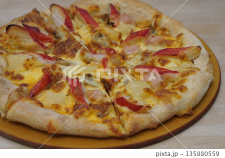 fresh pizza with crab sticks, mushrooms, and pineapple placed in a wooden tray with handle on the table background, food, eat, hot, copy space fresh pizza with crab sticks, mushrooms, and pineapple placed in a wooden tray with handle on the table background, food, eat, hot, copy space 135880559
