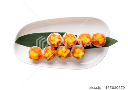 Top view of salmon and mango sushi on rice, served on bamboo leaf 135880670
