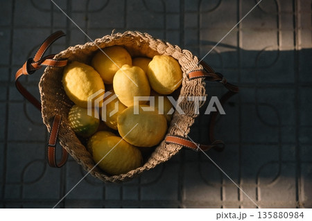 Fresh lemons in a woven basket placed on a stone surface during daylight Fresh lemons in a woven basket placed on a stone surface during daylight 135880984