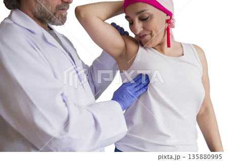 Doctor performing breast examination on woman patient with headscarf Doctor performing breast examination on woman patient with headscarf 135880995