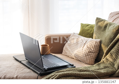 Laptop and Coffee Mug on Lap Desk. Cozy Morning Home Workspace with Green Accents 135881147