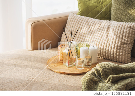 Candles and Reed Diffuser on Wooden Tray. Cozy Home Decor lifestyle with Cushions 135881151