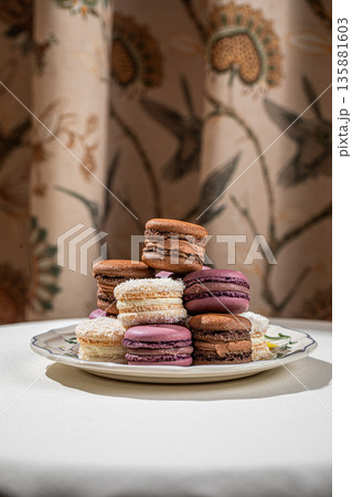 Assorted macarons stacked on decorative plate Assorted macarons stacked on decorative plate 135881603