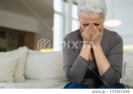 Sad tired ill sick lonely disappointed older senior woman sitting at home alone. Unhappy mature grandmother experiencing grief relative death bad news. Stressed elder lady suffering from loneliness Sad tired ill sick lonely disappointed older senior woman sitting at home alone. Unhappy mature grandmother experiencing grief relative death bad news. Stressed elder lady suffering from loneliness 135881846