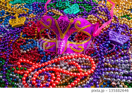 Mardi Gras beads in glittering yellow, green, purple, and gold. Sparkling festive background for Mardi Gras in traditional colors. Mardi Gras beads in glittering yellow, green, purple, and gold. Sparkling festive background for Mardi Gras in traditional colors. 135882646