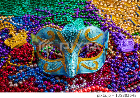 Mardi Gras beads in glittering yellow, green, purple, and gold. Sparkling festive background for Mardi Gras in traditional colors. Mardi Gras beads in glittering yellow, green, purple, and gold. Sparkling festive background for Mardi Gras in traditional colors. 135882648