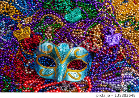 Mardi Gras beads in glittering yellow, green, purple, and gold. Sparkling festive background for Mardi Gras in traditional colors. Mardi Gras beads in glittering yellow, green, purple, and gold. Sparkling festive background for Mardi Gras in traditional colors. 135882649