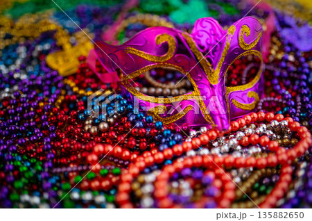Mardi Gras beads in glittering yellow, green, purple, and gold. Sparkling festive background for Mardi Gras in traditional colors. Mardi Gras beads in glittering yellow, green, purple, and gold. Sparkling festive background for Mardi Gras in traditional colors. 135882650