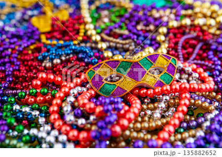 Mardi Gras beads in glittering yellow, green, purple, and gold. Sparkling festive background for Mardi Gras in traditional colors. Mardi Gras beads in glittering yellow, green, purple, and gold. Sparkling festive background for Mardi Gras in traditional colors. 135882652