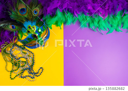 Vibrant Mardi Gras background with mask, beads, and festive decorations Vibrant Mardi Gras background with mask, beads, and festive decorations 135882682