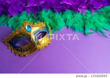 Vibrant Mardi Gras background with mask, beads, and festive decorations Vibrant Mardi Gras background with mask, beads, and festive decorations 135882693