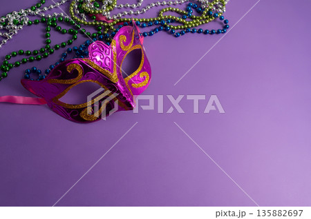 Vibrant Mardi Gras background with mask, beads, and festive decorations 135882697