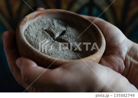Hands with gray ash cross in church on stained glass window. background. Ash Wednesday Hands with gray ash cross in church on stained glass window. background. Ash Wednesday 135882749