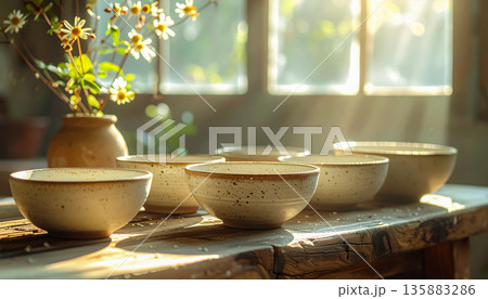 木漏れ日の中で並ぶ手作り陶器の食器 ／ 暖かく自然な暮らしを感じるライフスタイルビジュアル 135883286