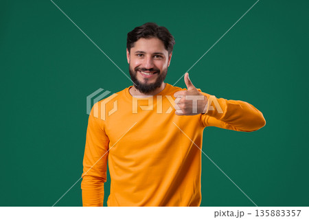 Handsome man With Hand Sign Like,thumbs Up Gesture. Happy Young Guy On green 135883357