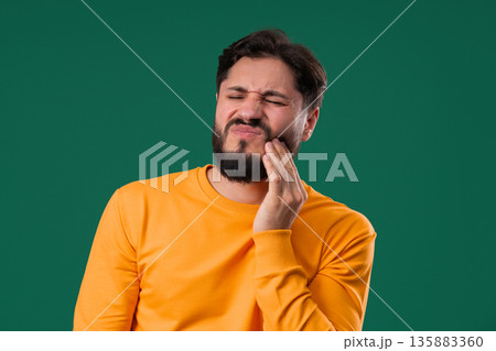 Mature Man Touching Cheek With Painful Expression, Reacting To Sudden Toothache Mature Man Touching Cheek With Painful Expression, Reacting To Sudden Toothache 135883360