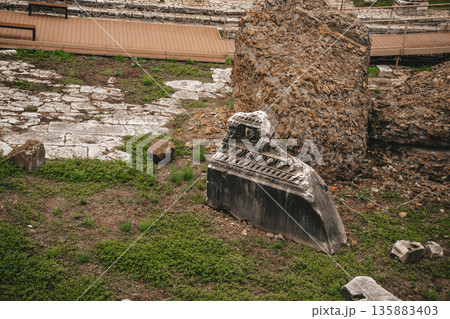 Ancient Roman Ruins with Stone Fragment and Grass at Archaeological Site 135883403