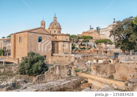 Panoramic View Of The Roman Forum. Ancient ruins, stone columns, historic landmarks bathed in warm sunlight. Panoramic View Of The Roman Forum. Ancient ruins, stone columns, historic landmarks bathed in warm sunlight. 135883428