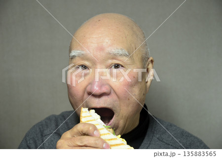ホットサンドを笑顔で食べる老人 ホットサンドを笑顔で食べる老人 135883565