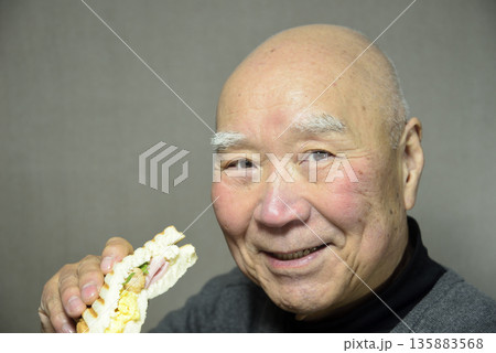 ホットサンドを笑顔で食べる老人 ホットサンドを笑顔で食べる老人 135883568