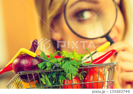 Woman investigating shopping backet with vegetables 135883749