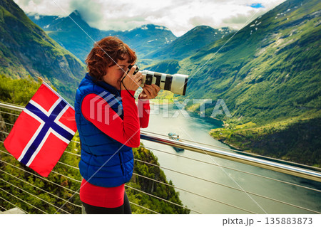Tourist taking photo of fjord landscape, Norway Tourist taking photo of fjord landscape, Norway 135883873