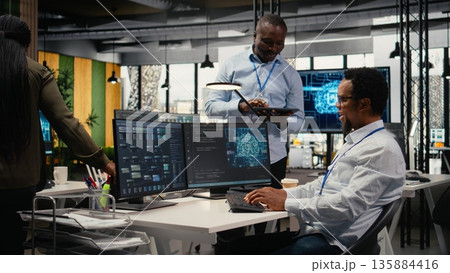 Smiling programmers working in AI startup train predictive models for language processing tasks. Cheerful IT professionals use machine learning technical expertise for complex tasks, camera A 135884416