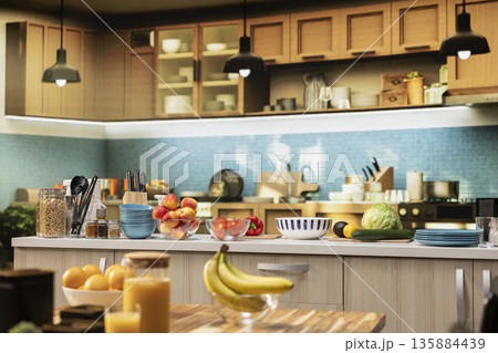 Empty modern kitchen interior in a contemporary apartment. Bright space includes a clean table, stylish kitchenware, fresh fruits and condiments on the counter. Healthy cooking in cozy home. 135884439
