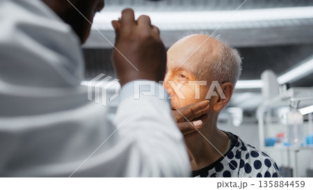 Medic in a clinical research procedure testing older patient with new pills, monitoring reactions and dosage outcome to ensure treatment safety and breakthrough discovery in medicine. Camera A. Medic in a clinical research procedure testing older patient with new pills, monitoring reactions and dosage outcome to ensure treatment safety and breakthrough discovery in medicine. Camera A. 135884459