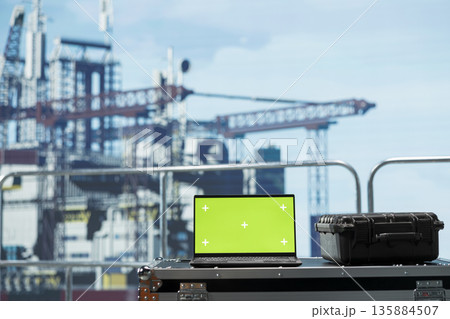 Chroma key laptop on offshore platform deck used to configure boat management systems for more efficient oil extraction. Isolated screen notebook on drilling rig ship used for seabed analysis Chroma key laptop on offshore platform deck used to configure boat management systems for more efficient oil extraction. Isolated screen notebook on drilling rig ship used for seabed analysis 135884507