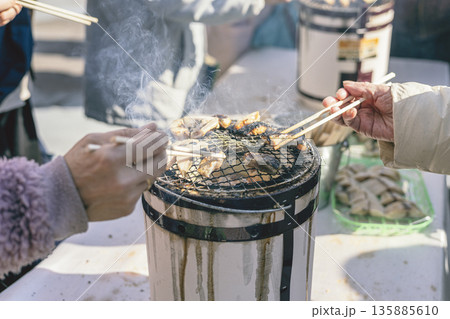 七輪で干物を焼く 炭火焼きの試食 手元クローズアップ 七輪で干物を焼く 炭火焼きの試食 手元クローズアップ 135885610