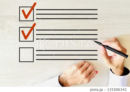 チェックリストにサインする男性の手元 チェックリストにサインする男性の手元 135886342