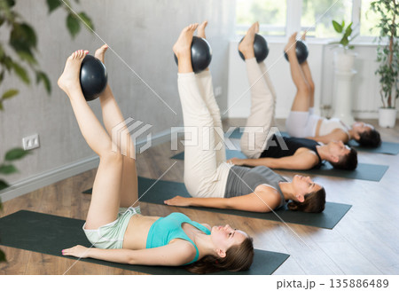 Young people doing softball pilates. Young people doing softball pilates. 135886489