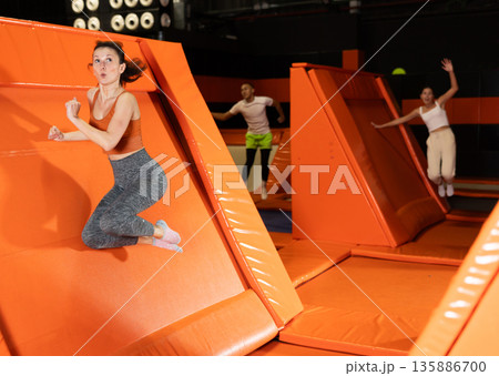 Emotional woman pushing off from angled surface in trampoline park Emotional woman pushing off from angled surface in trampoline park 135886700