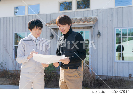 家の前で図面を見る職人たち 家の前で図面を見る職人たち 135887034