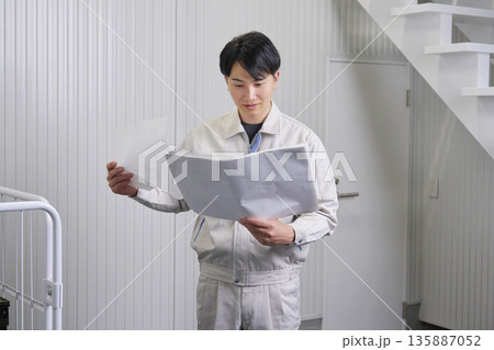 図面を見る作業員　倉庫 135887052