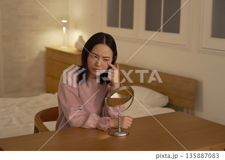 夜に目元を気にする女性 135887083