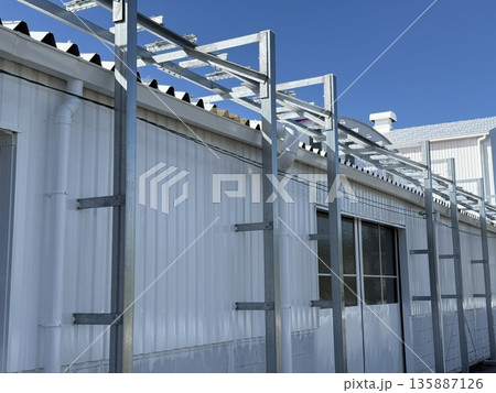 白い工場建物と鉄骨フレーム 青空の下の建築外観 白い工場建物と鉄骨フレーム 青空の下の建築外観 135887126