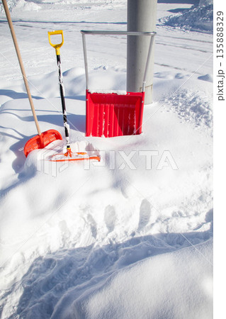 雪に埋もれた除雪用具と冬の生活風景 雪に埋もれた除雪用具と冬の生活風景 135888329