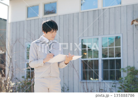 家の前に立つ作業着の男性 家の前に立つ作業着の男性 135888786