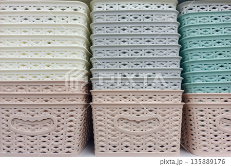 Stacks of Pastel Colored Plastic Storage Baskets with Woven Texture 135889176
