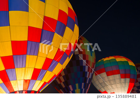 colorful hot air balloons glowing against dark night sky 135889481