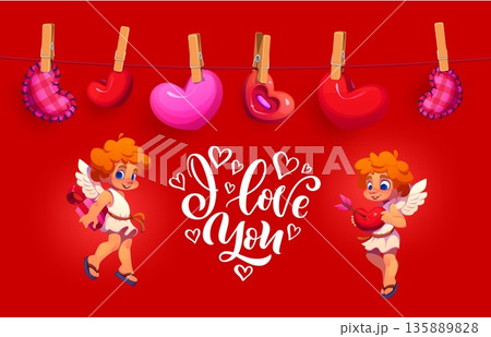 Happy Valentine day greeting card featuring two cute playful cupids with wings, surrounded by heart shaped plush decorations hanging on a clothesline, with a white I love you script on red background 135889828