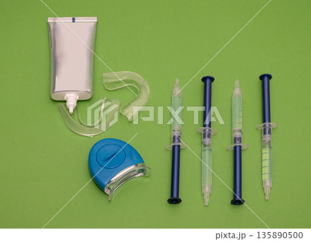 Teeth whitening equipment on green background 135890500