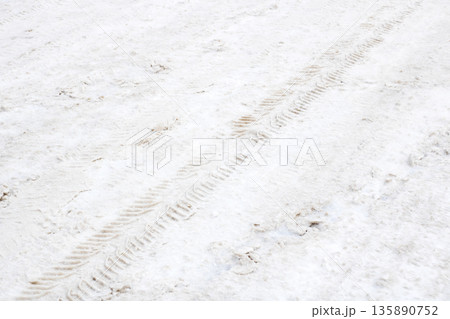 Serene winter scene, Quiet icy environment with snow and tire tracks conveying serenity Serene winter scene, Quiet icy environment with snow and tire tracks conveying serenity 135890752