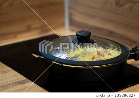 Steam rises from sizzling cookware, Intimate closeup capturing warm kitchen cooking ambiance 135890827