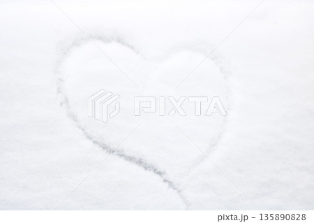 Gentle heart silhouette etched into pristine snow amidst quiet winter surroundings 135890828